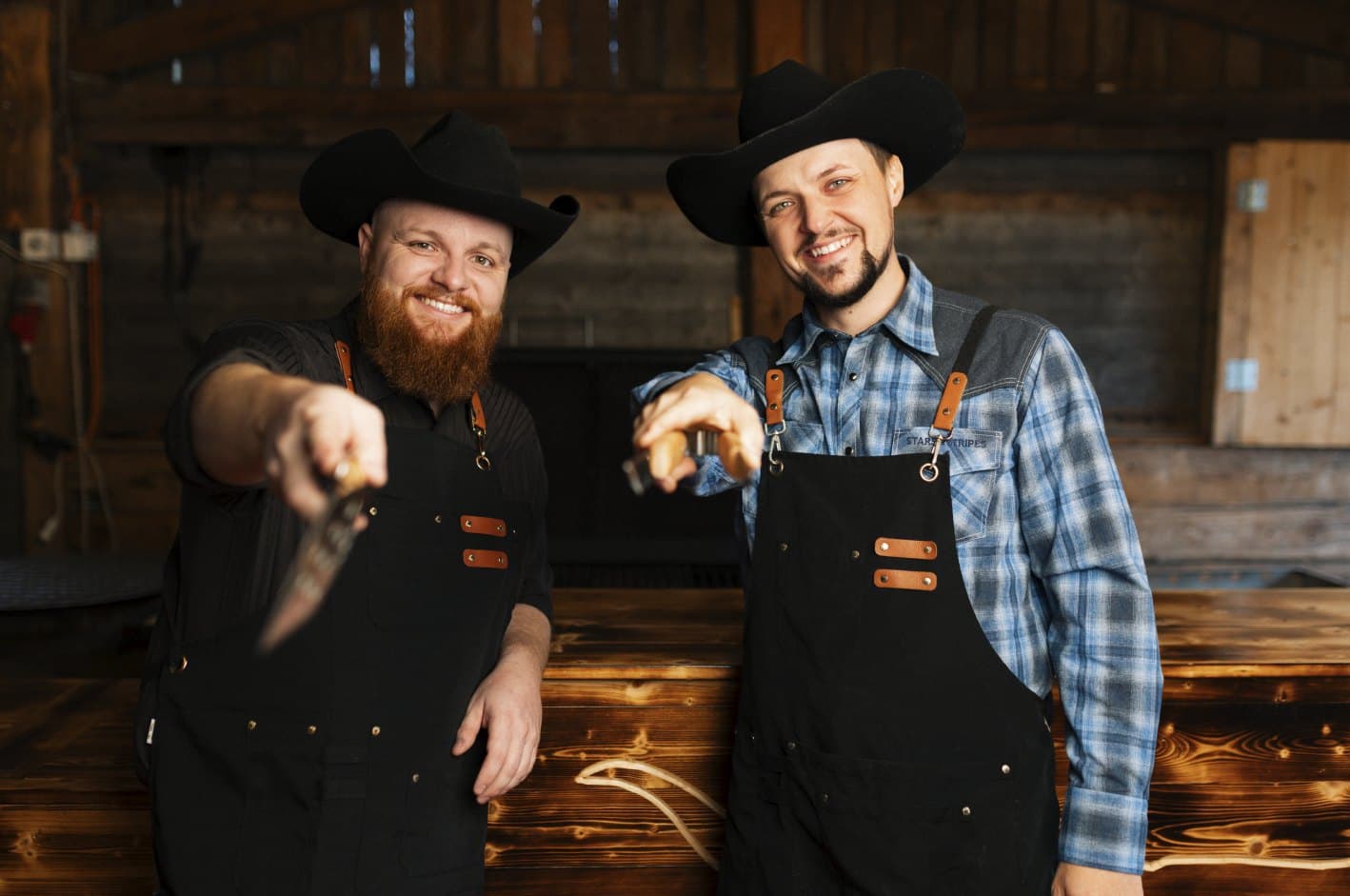 Pascal und Philipp mit Cowboyhüten zeigen lachend in die Kamera