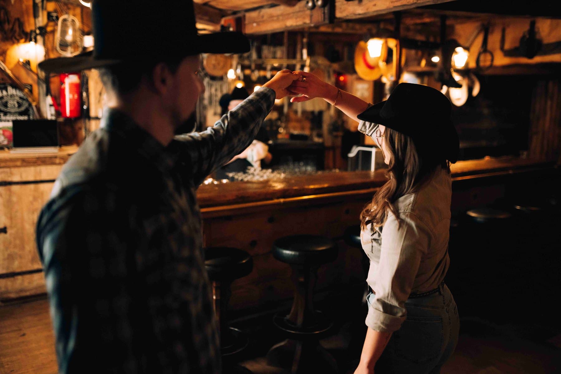 Ein Paar mit Cowboyhüten tanzt an der Bar des Saloons