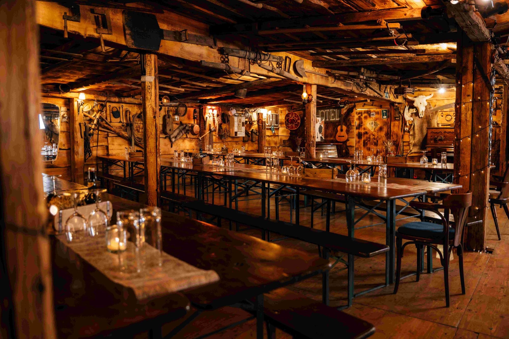 Der Saloon mit langen Tischen, Barhockern und Holzbalken