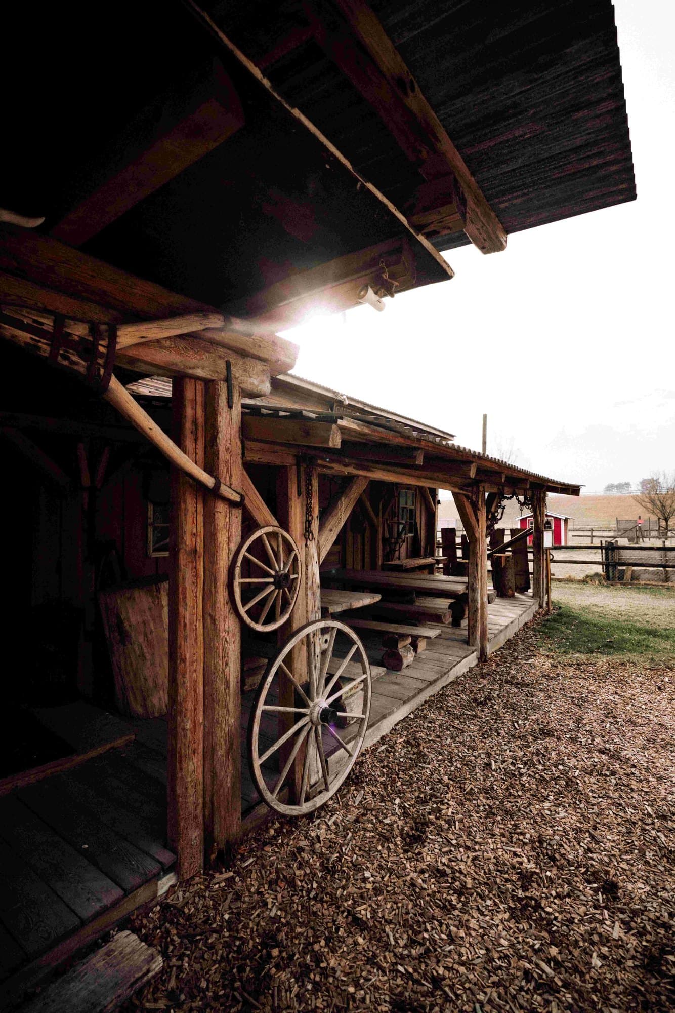 Wagenrad und Holzfassade im Gegenlicht
